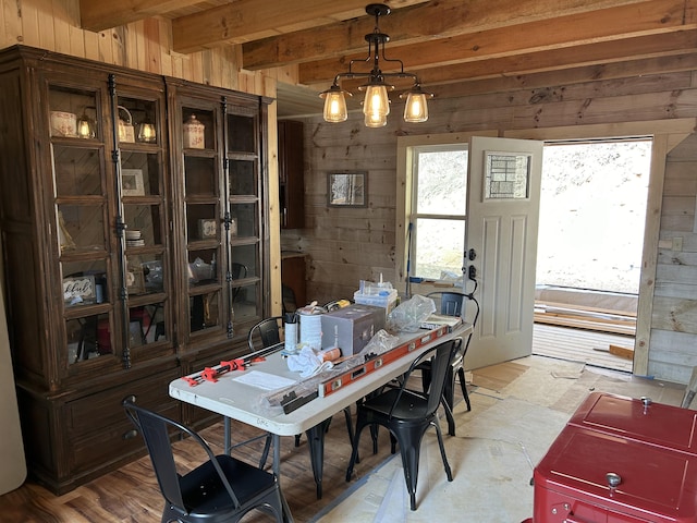 office featuring beamed ceiling, wood walls, and a notable chandelier