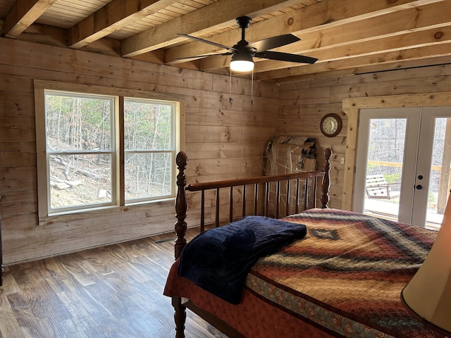 bedroom featuring wood walls, multiple windows, access to exterior, and wood finished floors