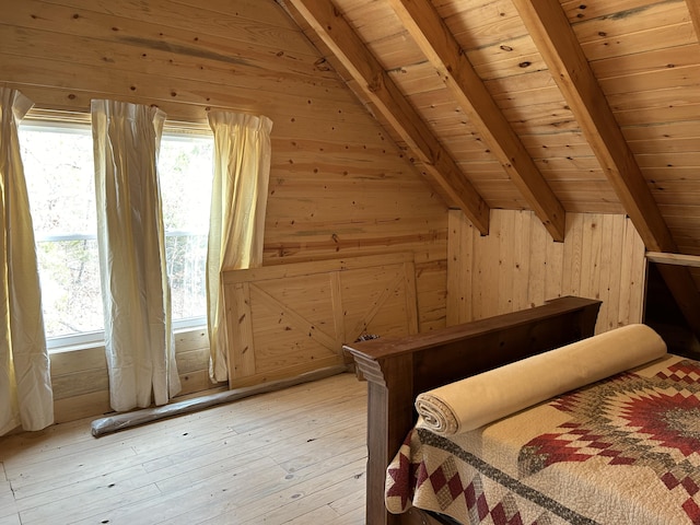 unfurnished bedroom with light wood-style floors, wood ceiling, wood walls, and beamed ceiling