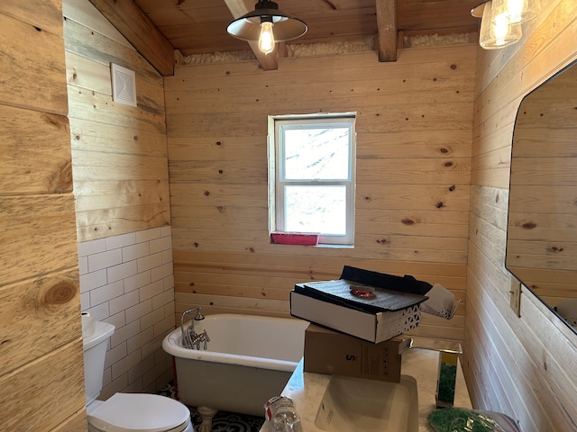 bathroom featuring a freestanding tub, wooden ceiling, wooden walls, and toilet