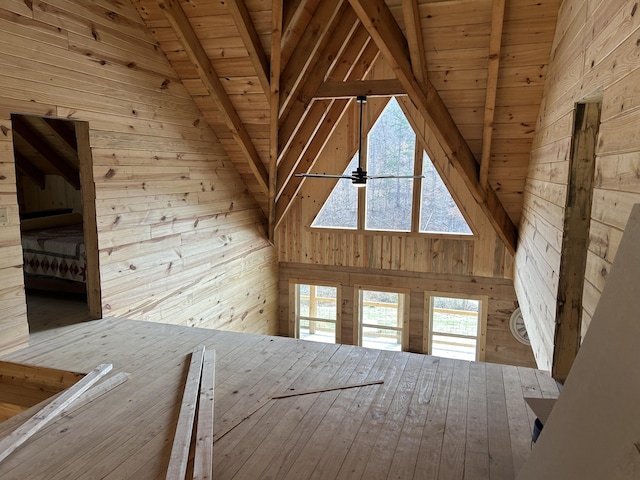 additional living space with a ceiling fan, wooden walls, high vaulted ceiling, wooden ceiling, and beamed ceiling