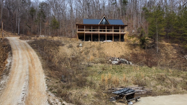 rear view of house featuring a view of trees