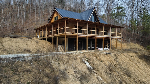 exterior space featuring metal roof and a forest view