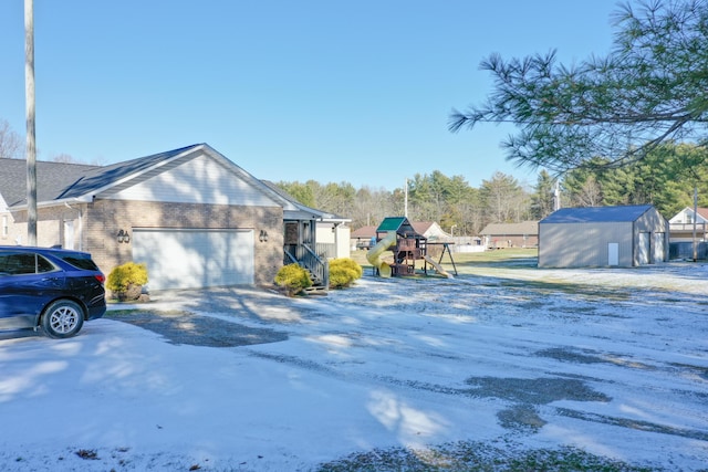 exterior space with a playground, a garage, and a shed