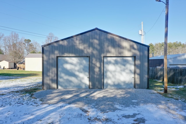 detached garage featuring fence