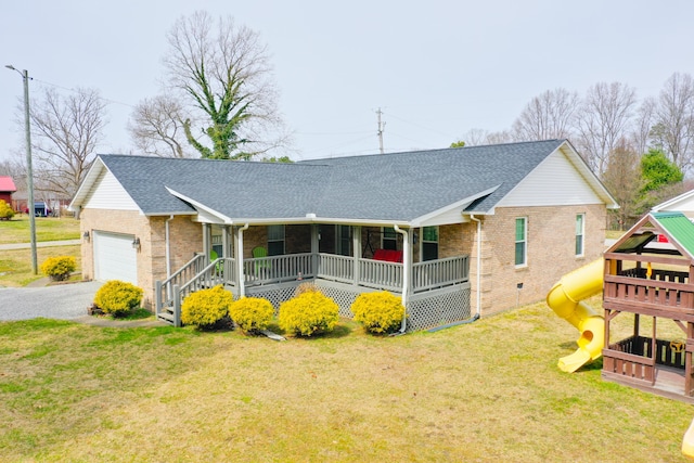 ranch-style house featuring a porch, a playground, a front yard, a shingled roof, and brick siding