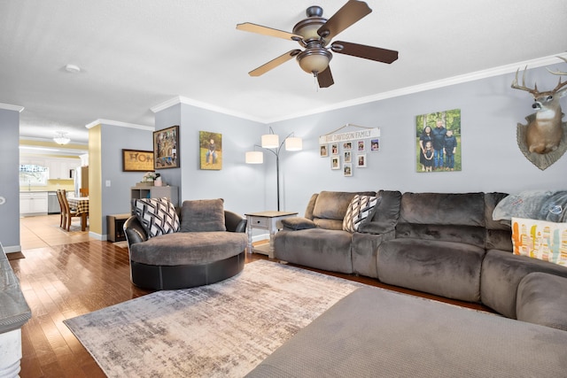 living area featuring ornamental molding, baseboards, a ceiling fan, and hardwood / wood-style floors