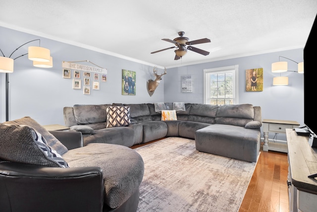 living area with hardwood / wood-style floors, crown molding, and a ceiling fan