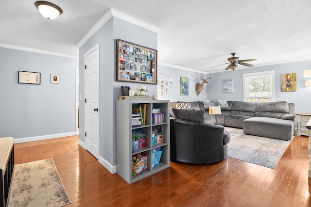 living room with crown molding, baseboards, hardwood / wood-style flooring, a textured ceiling, and a ceiling fan