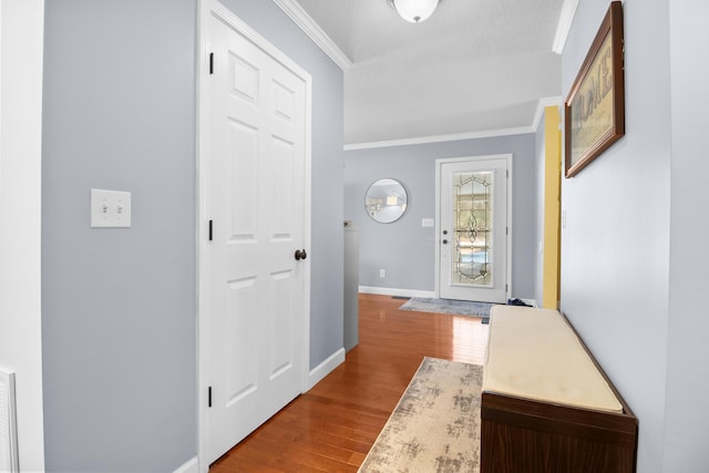 foyer entrance featuring baseboards, dark wood-style flooring, and crown molding