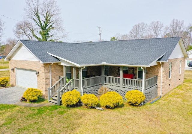 ranch-style home with a porch, a garage, a front lawn, and roof with shingles