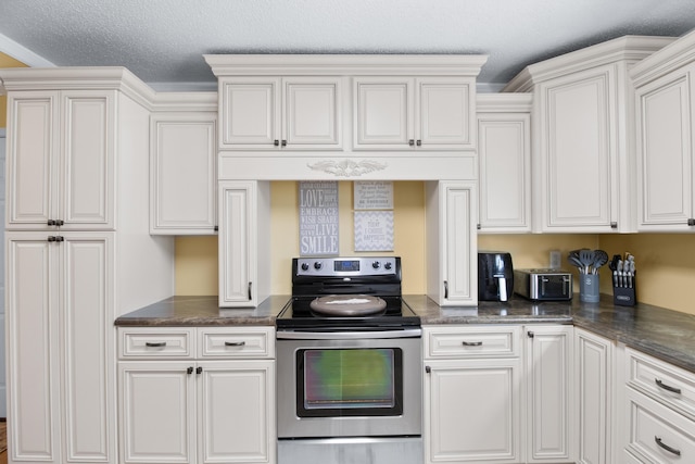 kitchen featuring dark countertops, stainless steel electric range, and white cabinetry