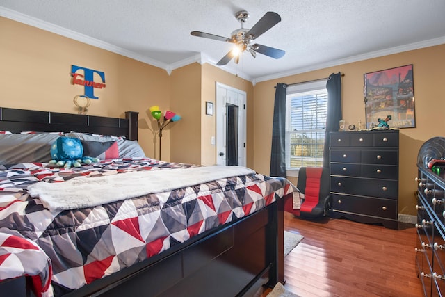 bedroom featuring ornamental molding, a textured ceiling, ceiling fan, and wood finished floors