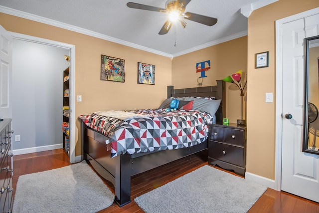 bedroom featuring baseboards, wood finished floors, a ceiling fan, and ornamental molding