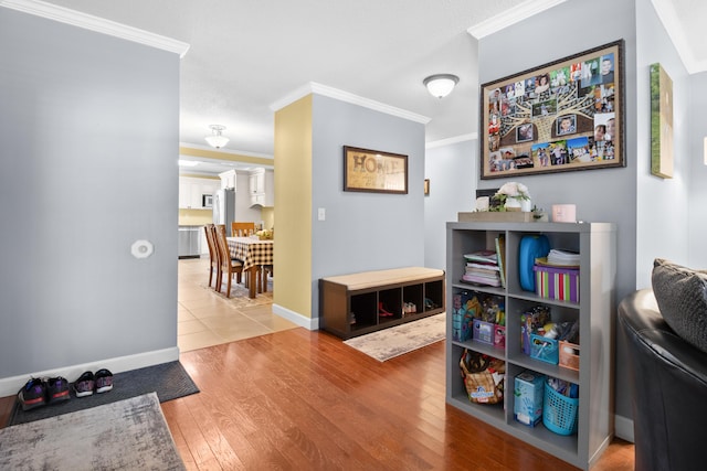 interior space featuring crown molding, wood finished floors, and baseboards