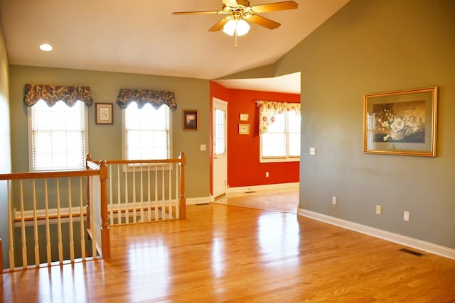 unfurnished room featuring light hardwood / wood-style floors, vaulted ceiling, and ceiling fan