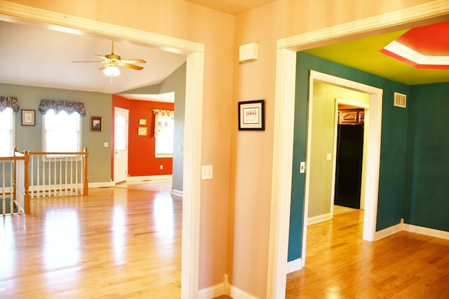 hall with light wood-type flooring and vaulted ceiling