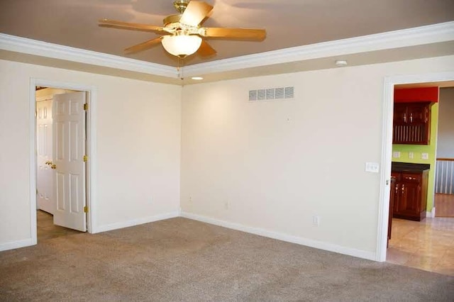 carpeted spare room featuring ceiling fan and crown molding