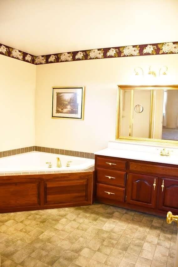 bathroom featuring vanity and a tub