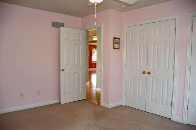 unfurnished bedroom with light carpet and a closet