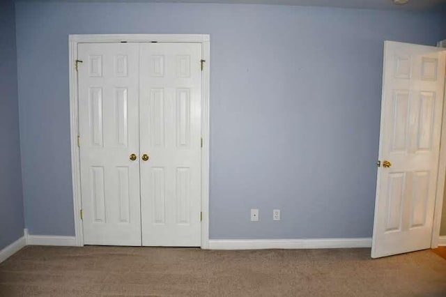 unfurnished bedroom featuring carpet flooring and a closet