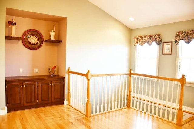 hallway with light hardwood / wood-style floors and vaulted ceiling