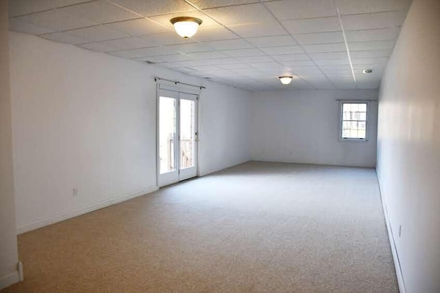 carpeted empty room with a paneled ceiling