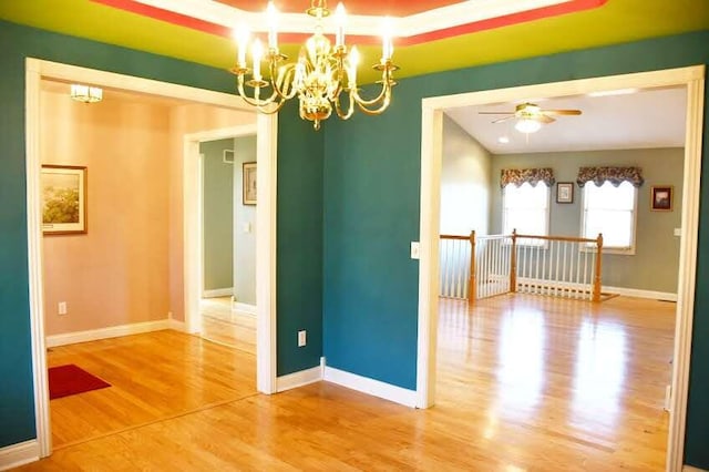 empty room featuring hardwood / wood-style floors and ceiling fan with notable chandelier