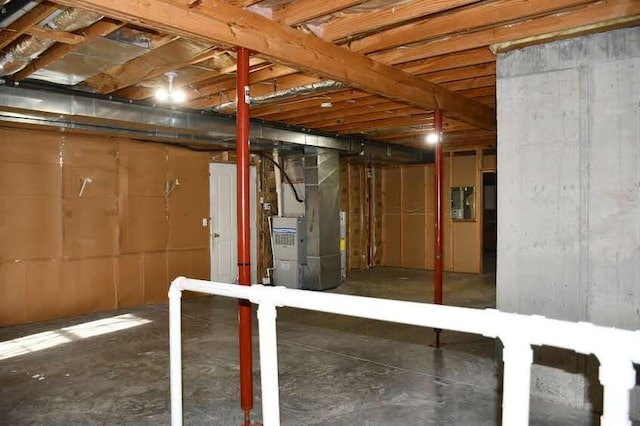 basement featuring electric panel and heating unit