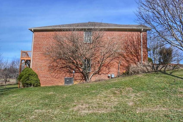 view of home's exterior with central AC, a wooden deck, and a lawn