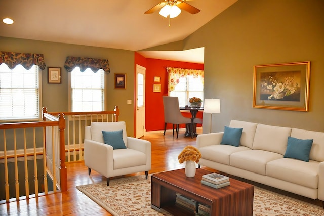 living room featuring ceiling fan, light wood-type flooring, and lofted ceiling