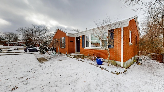 bungalow featuring brick siding