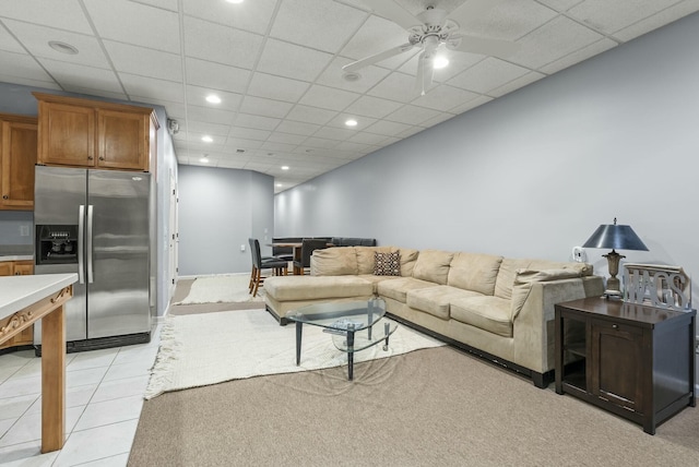 living room with ceiling fan, a paneled ceiling, and light tile patterned floors