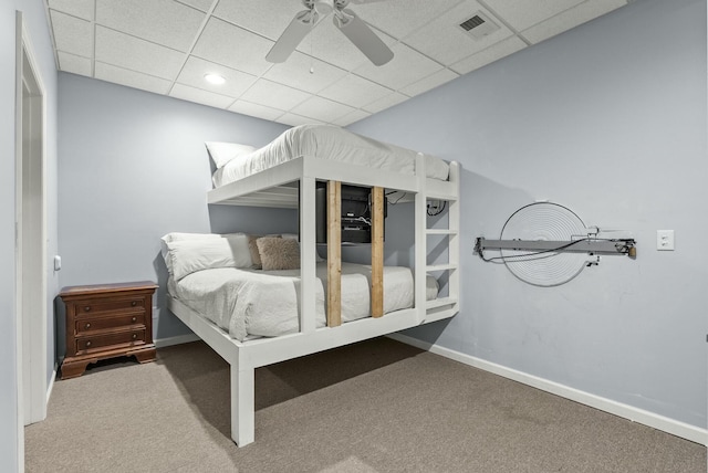 bedroom featuring a drop ceiling, ceiling fan, and carpet