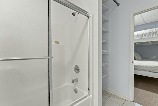 bathroom with tile patterned floors and shower / bath combination with glass door