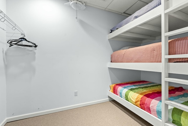 bedroom featuring carpet floors and a drop ceiling