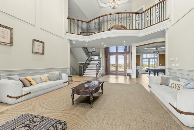 living room featuring french doors, crown molding, pool table, light tile patterned floors, and a towering ceiling