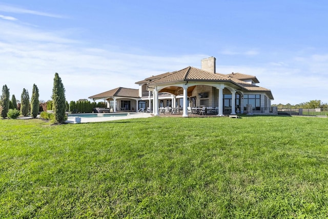 back of house with a patio area and a lawn