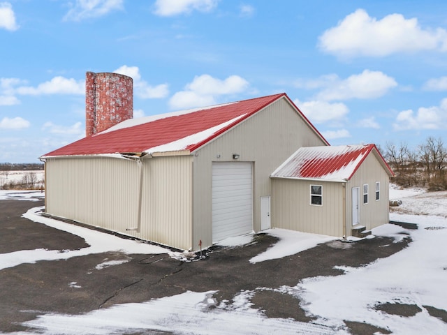 snow covered structure featuring a garage