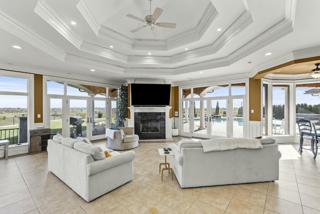 living room featuring french doors, ceiling fan, ornamental molding, and a raised ceiling