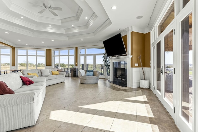 living room featuring ornamental molding, a tray ceiling, and a premium fireplace