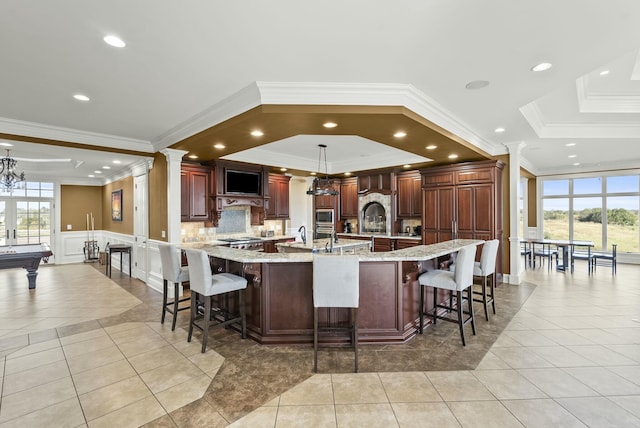 kitchen featuring light tile patterned flooring and a large island with sink