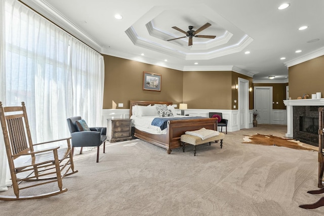 carpeted bedroom with multiple windows, ornamental molding, a high end fireplace, and ceiling fan