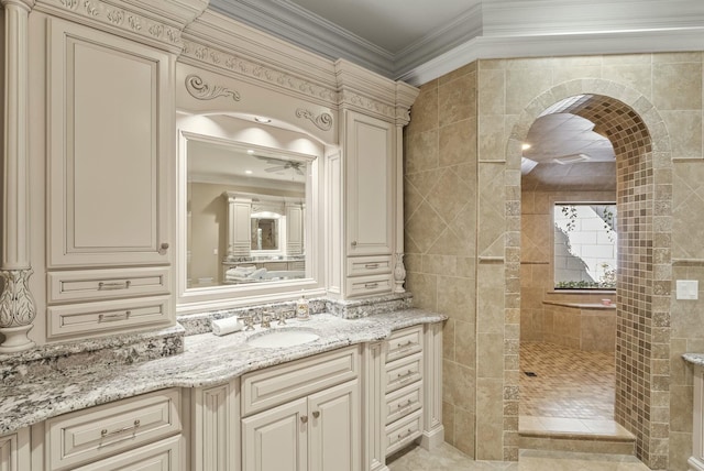 bathroom with vanity, a tile shower, crown molding, and tile walls