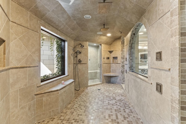 bathroom featuring a shower with door, tile patterned flooring, and tile walls