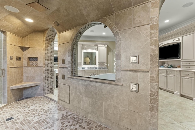 bathroom featuring crown molding, lofted ceiling, tile walls, and a tile shower