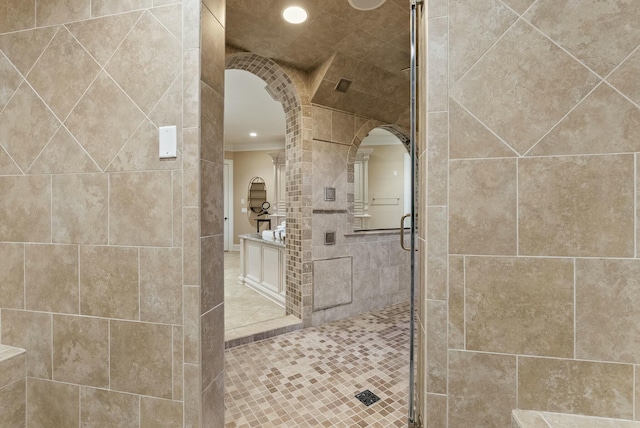 bathroom with an enclosed shower, ornamental molding, and tile walls