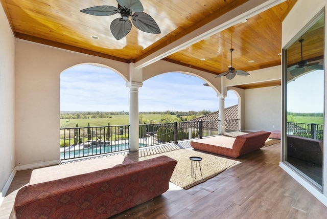 view of patio / terrace with a rural view, a fenced in pool, a balcony, and ceiling fan