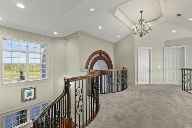 hallway with vaulted ceiling, crown molding, carpet floors, and a notable chandelier