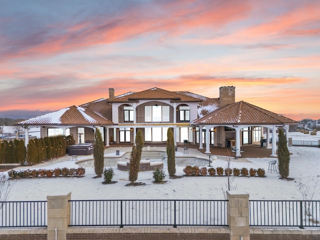 mediterranean / spanish house with a hot tub and a gazebo